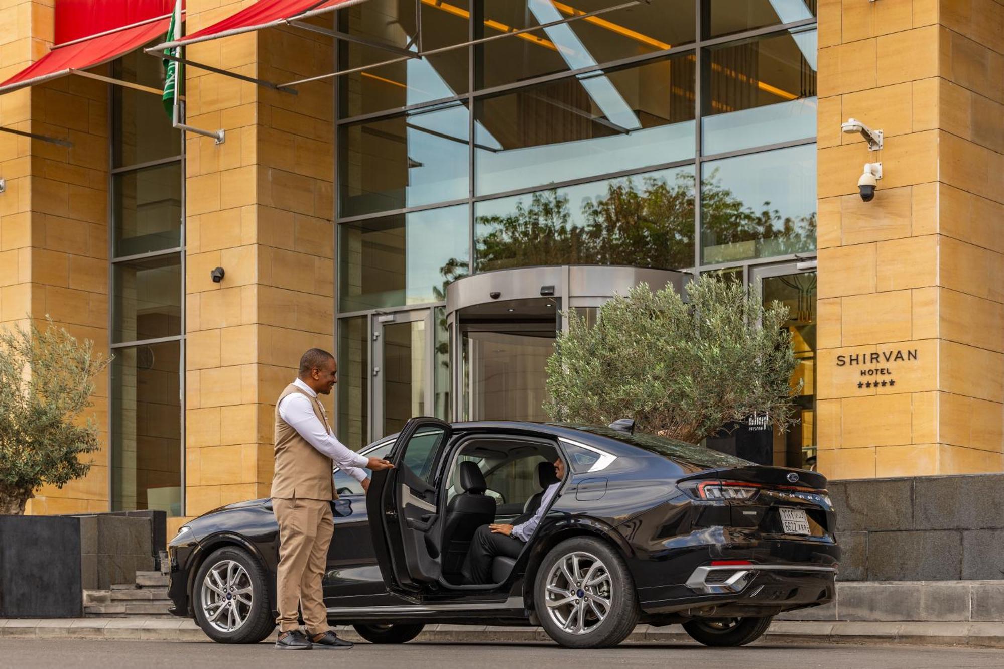 Shirvan Hotel City Yard Jiddah Esterno foto A chauffeur opening the door of a car